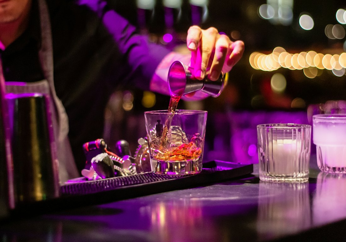 Mixologue versant un cocktail au bar